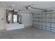 Well-lit garage with garage door, water heater and HVAC unit on an elevated platform at 13083 Sw 61St Place Rd, Ocala, FL 34481