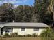 Light green house with mature landscaping and a spacious yard at 1105 Ne 45 Pl, Ocala, FL 34479