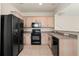 Traditional kitchen features ample cabinet space, black appliances, and tiled flooring at 4230 Sw 50Th Cir, Ocala, FL 34474
