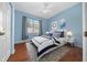 Bedroom featuring hardwood floors, blue walls, a large window and a beautifully decorated bed at 8655 Sw 86Th Cir, Ocala, FL 34481