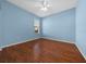 This bedroom features beautiful wood floors, a ceiling fan, a window, and light blue walls at 8655 Sw 86Th Cir, Ocala, FL 34481