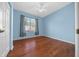 Bedroom featuring hardwood floors, blue walls, and a large window at 8655 Sw 86Th Cir, Ocala, FL 34481