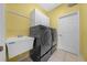Spacious laundry room with black washer and dryer set, large utility sink and ample storage at 8655 Sw 86Th Cir, Ocala, FL 34481