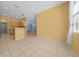 Open living area with bright yellow accent walls, tile flooring, and access to kitchen at 8655 Sw 86Th Cir, Ocala, FL 34481