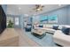 Decorated living room with a large couch, blue accents, and natural light from the front windows at 8655 Sw 86Th Cir, Ocala, FL 34481