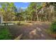 A view of the backyard with a chair and a swing set, surrounded by towering trees at 6 Fisher Way Pl, Ocklawaha, FL 32179