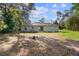 View of a backyard featuring a simple lawn and the home's exterior under a partly cloudy sky at 6 Fisher Way Pl, Ocklawaha, FL 32179