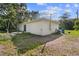 The backyard featuring lawn space and the home's exterior under a partly cloudy sky at 6 Fisher Way Pl, Ocklawaha, FL 32179