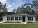 Charming single-story home with light siding, dark shutters, and a well-manicured lawn at 6 Fisher Way Pl, Ocklawaha, FL 32179