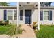 Close up of covered front porch with dark door, light columns, dark shutters at 6 Fisher Way Pl, Ocklawaha, FL 32179