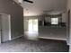 Open layout of the living room that leads to a sliding glass door and adjacent kitchen at 6 Fisher Way Pl, Ocklawaha, FL 32179