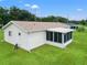 Rear view of house showcasing screened porch and grassy yard at 6248 Sw 103Rd Street Rd, Ocala, FL 34476