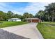 Charming single-story home with a long driveway, mature palm trees, and separate garage at 49 Fisher Way, Ocklawaha, FL 32179