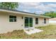 Rear exterior showcasing sliding glass doors and windows illuminating the home with natural light and a small patio at 1 Pine Trace Trl, Ocala, FL 34472