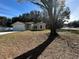 Tan house with white trim and a large tree in front at 1 Pine Trace Trl, Ocala, FL 34472