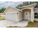 Inviting front exterior featuring an attached garage, classic archway, and manicured lawn; a charming home at 1 Pine Trace Trl, Ocala, FL 34472