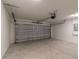 View of an empty, spacious two-car garage with a modern door and lighting, ready for vehicles and storage at 1 Pine Trace Trl, Ocala, FL 34472