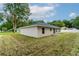 Tan house with gray sliding glass door and a grassy yard at 1 Pine Trace Trl, Ocala, FL 34472