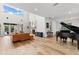 Bright living room featuring hardwood floors, a fireplace, and a grand piano at 2291 Sw 76Th Ln, Ocala, FL 34476