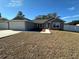 Single-story home with gray exterior, attached garage, and freshly landscaped lawn at 253 Locust Pass Loop, Ocala, FL 34472