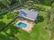 Aerial view showcasing the home, pool, and extensive green space of the property at 11831 Sw Highway 484, Dunnellon, FL 34432