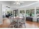 Cozy dining area with hardwood floors, a round table, and large windows overlooking the backyard and pool at 11831 Sw Highway 484, Dunnellon, FL 34432