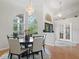 Chandelier lighting above dining table with four chairs, hardwood floors and large windows at 11831 Sw Highway 484, Dunnellon, FL 34432