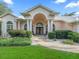 Grand home entrance with classic columns, a double door and a beautifully landscaped front yard at 11831 Sw Highway 484, Dunnellon, FL 34432