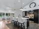 Modern kitchen featuring a center island with seating, dark cabinetry, and a spacious dining area with natural light at 11831 Sw Highway 484, Dunnellon, FL 34432