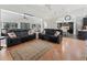 Inviting living room with hardwood floors, comfortable black seating, and an open layout to the kitchen and dining area at 11831 Sw Highway 484, Dunnellon, FL 34432