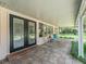 Covered patio with brick pavers, ideal for outdoor seating, and serene backyard views at 11831 Sw Highway 484, Dunnellon, FL 34432