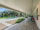 Relaxing covered patio with stone pavers overlooking the pool and lush green backyard at 11831 Sw Highway 484, Dunnellon, FL 34432