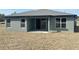 Home's back exterior features a sliding glass door to covered porch and views of the yard at 4544 Sw 156 Pl, Ocala, FL 34473