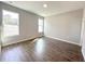 This bedroom features wood-look tile flooring and two large windows for natural light at 4544 Sw 156Th Pl, Ocala, FL 34473