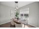 Dining area illuminated by modern pendant lighting, complementing the inviting table setting and sunlit windows at 4544 Sw 156 Pl, Ocala, FL 34473