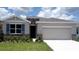 Charming single-story home with stone accents, blue shutters, a two car garage, and a well-manicured lawn at 3148 Canopy Oak Blvd, Wildwood, FL 34785