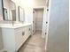 A white double sink vanity sits next to a doorway to the walk-in closet at 4872 Sw 100Th St, Ocala, FL 34476