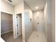 Modern walk-in shower with tiled walls, niche, and doorways to the walk-in closet at 4872 Sw 100Th St, Ocala, FL 34476