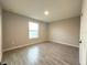 An empty bedroom features wood-look tile floors and a single window at 4872 Sw 100Th St, Ocala, FL 34476