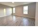 Empty bedroom showcasing tile floors and natural light streaming through two large windows at 4872 Sw 100Th St, Ocala, FL 34476