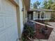 Exterior of the house, showing the garage, air conditioner, and the front entrance with landscaping at 9180 Sw 202Nd Avenue Road, Dunnellon, FL 34431