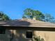 Home exterior featuring roof detail and mature trees in background at 9180 Sw 202Nd Avenue Road, Dunnellon, FL 34431