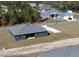 An aerial view displays a modern home design set within a tranquil neighborhood surrounded by lush trees at 4062 Sw 114Th St, Ocala, FL 34476