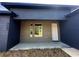 Modern home featuring a brown wood paneled entrance complemented by dark blue stucco walls and a concrete walkway at 4062 Sw 114Th St, Ocala, FL 34476