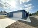 Contemporary home featuring a neutral-tone stucco exterior, a concrete driveway and walkway, and a two-car garage at 4062 Sw 114Th St, Ocala, FL 34476