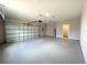 View of a spacious garage with epoxy flooring and a convenient access door at 4062 Sw 114Th St, Ocala, FL 34476