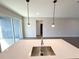 Kitchen island featuring a stainless steel sink with modern pendant lighting at 4062 Sw 114Th St, Ocala, FL 34476