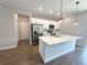 Well-lit kitchen features an island, stainless steel appliances, white shaker cabinets, and modern pendant lighting at 4062 Sw 114Th St, Ocala, FL 34476