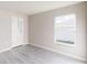 Bright bedroom with grey vinyl flooring and a large window at 5348 Se 91St Pl, Ocala, FL 34480