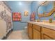 Bathroom featuring a white tiled countertop, light wood cabinets, a decorative shower curtain, and blue walls at 4348 Sw Deepwater Ct, Dunnellon, Fl, FL 34431